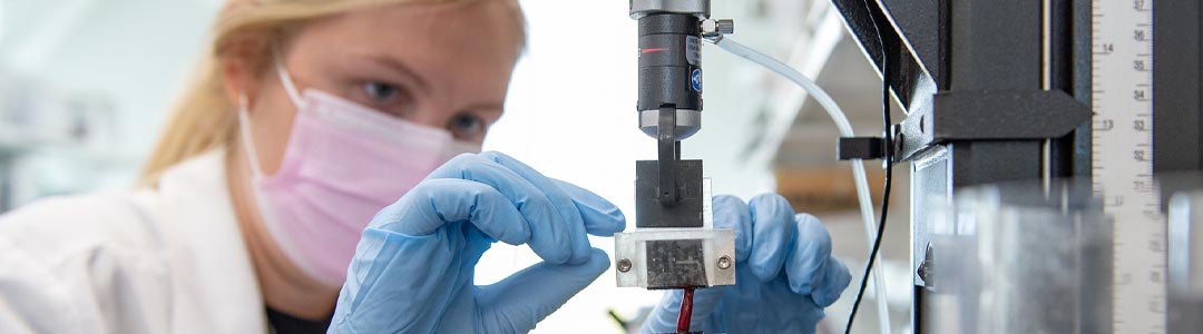 a woman adjusts equipment in a lab